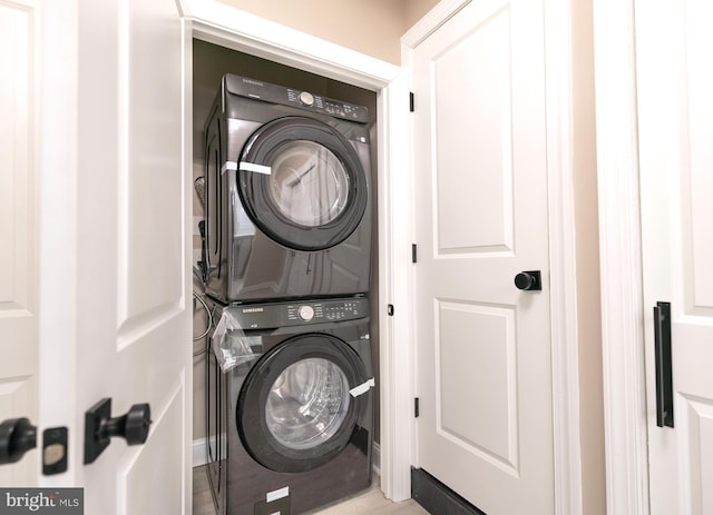 laundry room featuring stacked washer / drying machine