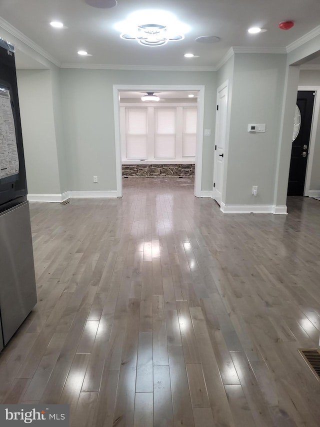 unfurnished living room with crown molding and wood-type flooring