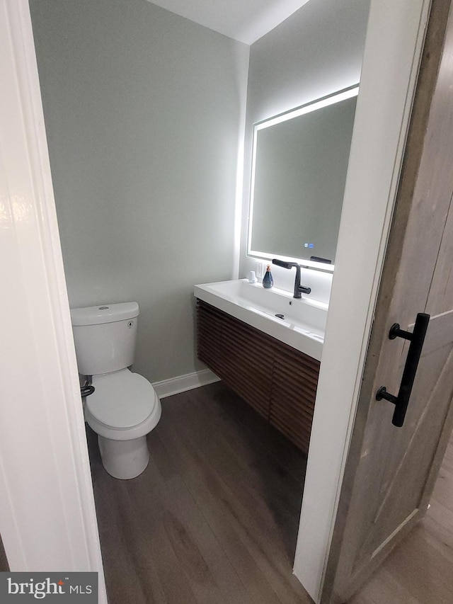 bathroom featuring vanity, hardwood / wood-style floors, and toilet