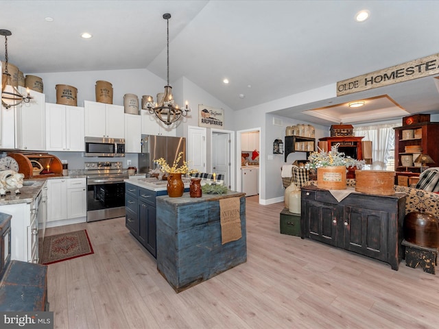 kitchen featuring an inviting chandelier, a center island, appliances with stainless steel finishes, and decorative light fixtures