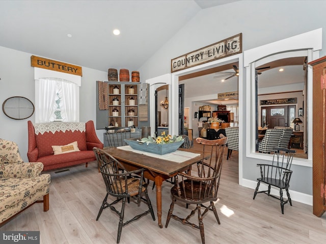 dining space with vaulted ceiling and light hardwood / wood-style floors