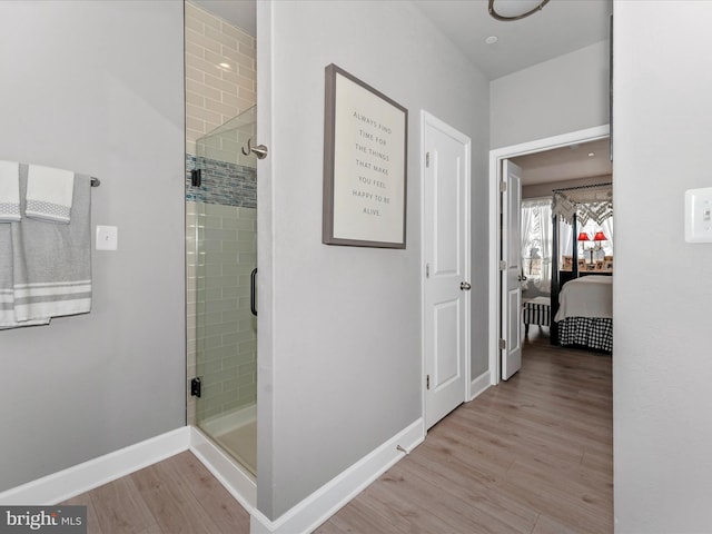 bathroom with hardwood / wood-style floors and a shower with door