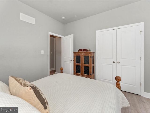 bedroom with light wood-type flooring and a closet