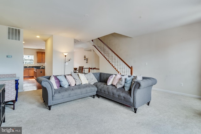 carpeted living room with sink