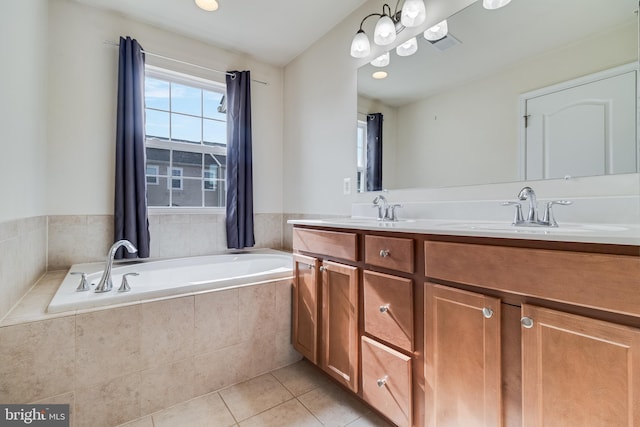 bathroom featuring a relaxing tiled tub, tile patterned floors, and vanity