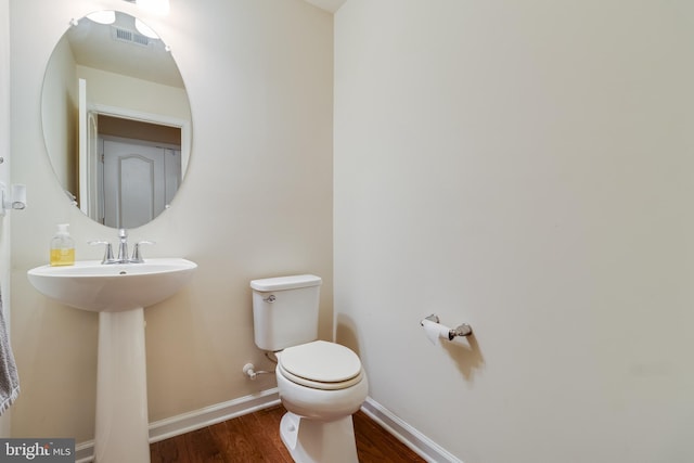 bathroom with hardwood / wood-style flooring and toilet