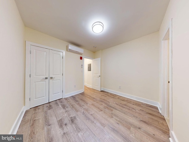 1821 T St NW, Washington, DC 20009 - unfurnished bedroom featuring light wood-type flooring, baseboards, an AC wall unit, and a closet