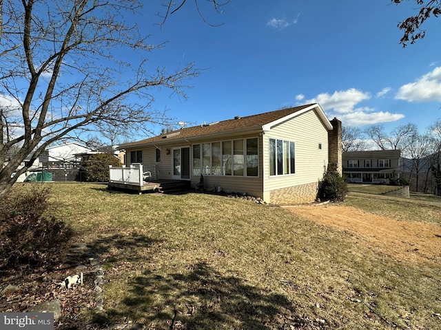 rear view of property with a yard and a deck