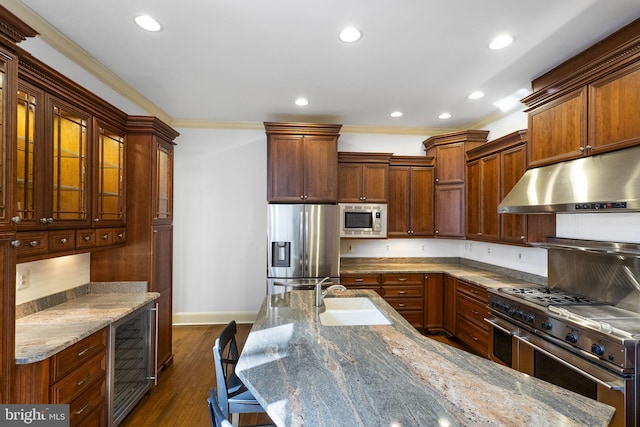 kitchen with sink, light stone counters, dark hardwood / wood-style flooring, stainless steel appliances, and beverage cooler