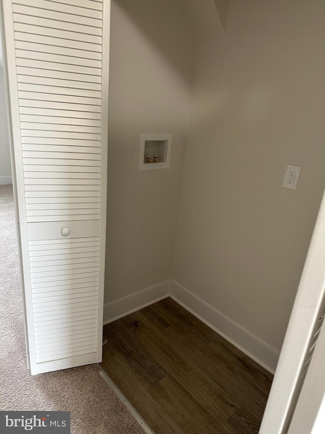 clothes washing area with dark wood-style floors, washer hookup, laundry area, and baseboards