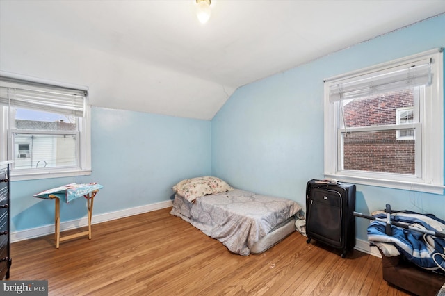 bedroom featuring light hardwood / wood-style flooring and vaulted ceiling