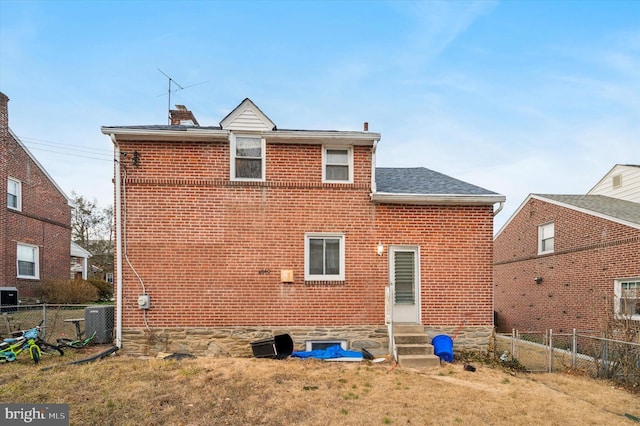 rear view of property with a yard and central AC