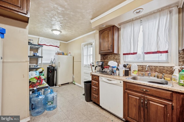 kitchen with tasteful backsplash, sink, white appliances, crown molding, and a textured ceiling