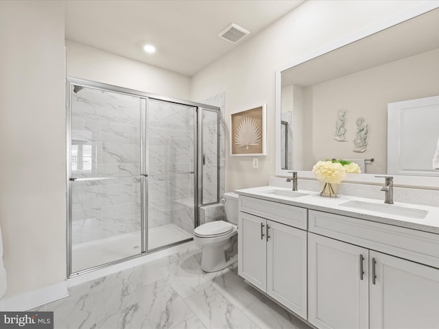 bathroom featuring vanity, a shower with shower door, and toilet