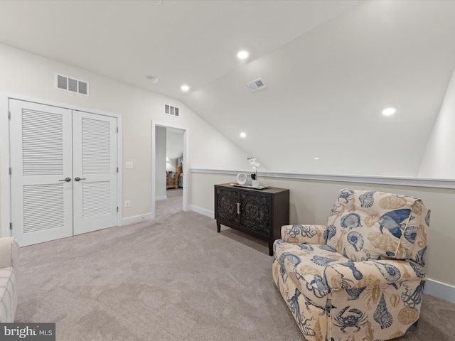 living area with vaulted ceiling and light carpet