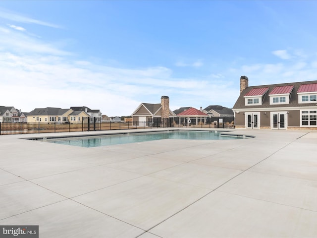 view of swimming pool with french doors and a patio