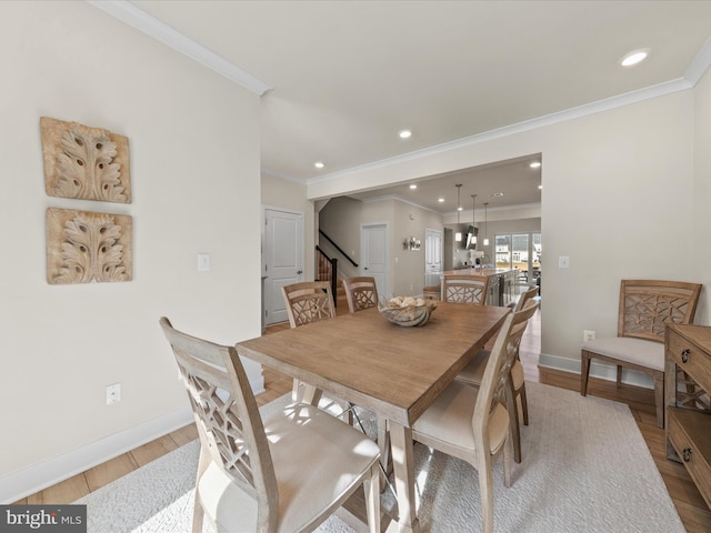 dining room with ornamental molding and light wood-type flooring
