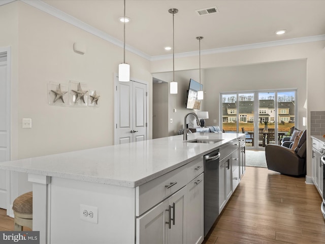 kitchen with sink, a kitchen island with sink, and hanging light fixtures