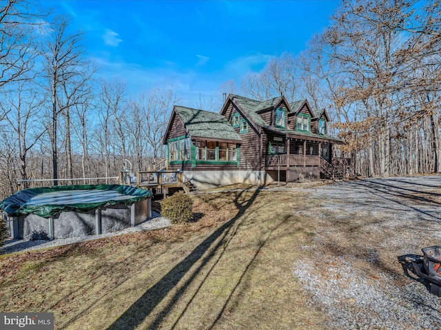 view of side of home with a covered pool, covered porch, and a lawn