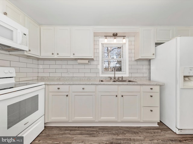 kitchen with tasteful backsplash, white appliances, a sink, and white cabinets