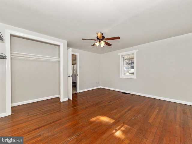 unfurnished bedroom with baseboards, a closet, visible vents, and dark wood-style flooring