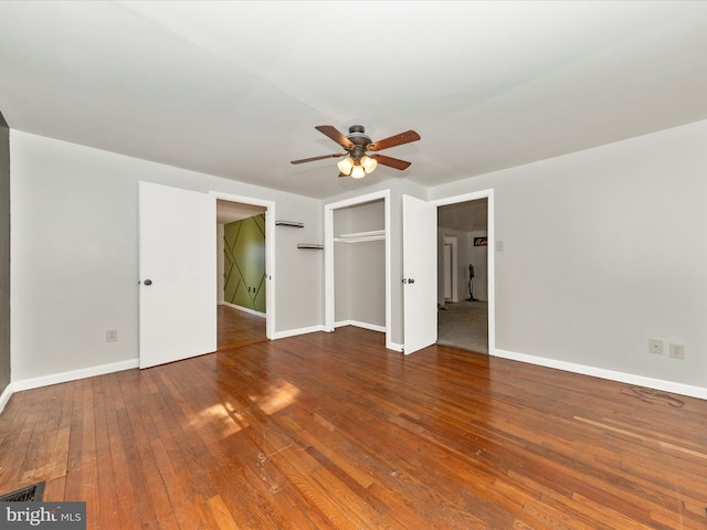 unfurnished bedroom featuring a ceiling fan, visible vents, baseboards, a closet, and hardwood / wood-style floors