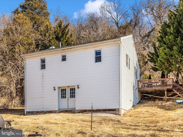 rear view of property with a yard and a wooden deck