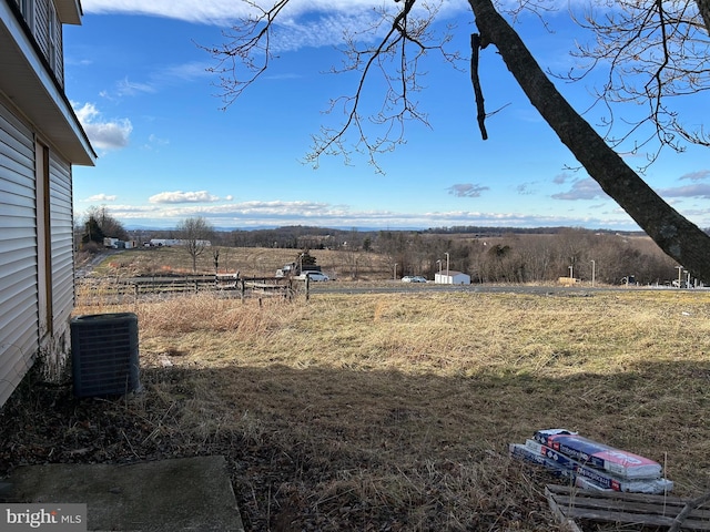 view of yard featuring central air condition unit and a rural view