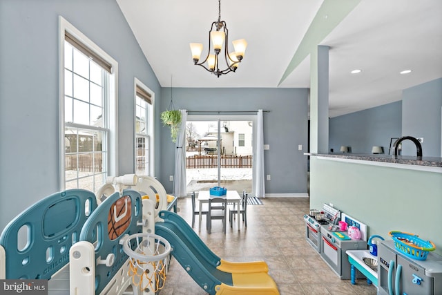 recreation room featuring vaulted ceiling, baseboards, recessed lighting, and a chandelier