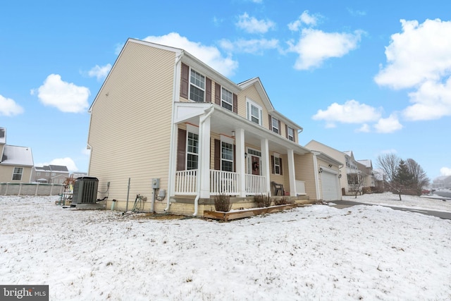 view of front facade featuring fence, central air condition unit, covered porch, and a garage