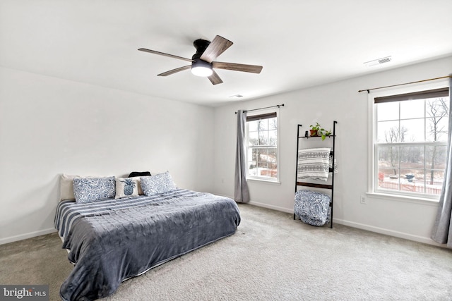 bedroom featuring baseboards, visible vents, a ceiling fan, and light carpet