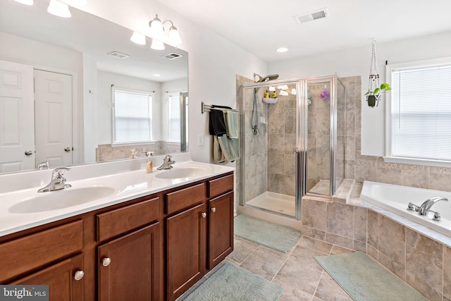 full bath featuring a shower stall, visible vents, a sink, and double vanity