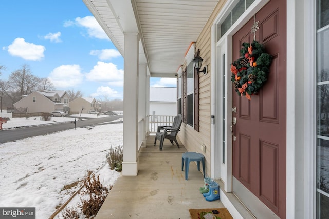 snow covered patio with a porch