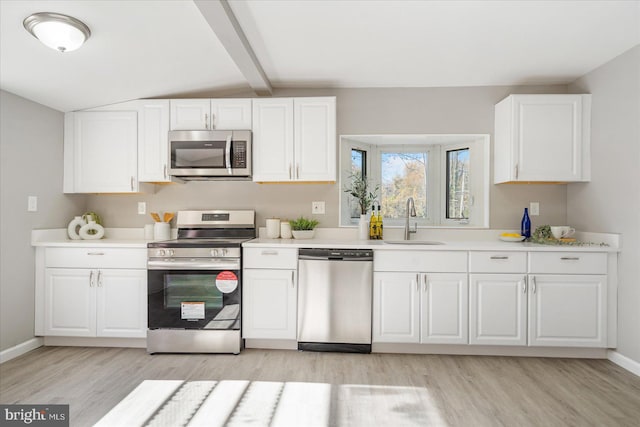 kitchen featuring stainless steel appliances, sink, and white cabinets