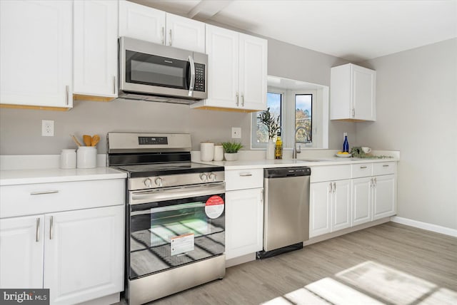 kitchen featuring white cabinetry, appliances with stainless steel finishes, sink, and light hardwood / wood-style floors