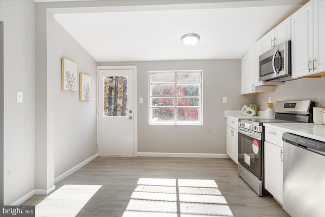 kitchen with white cabinetry, appliances with stainless steel finishes, and light hardwood / wood-style flooring