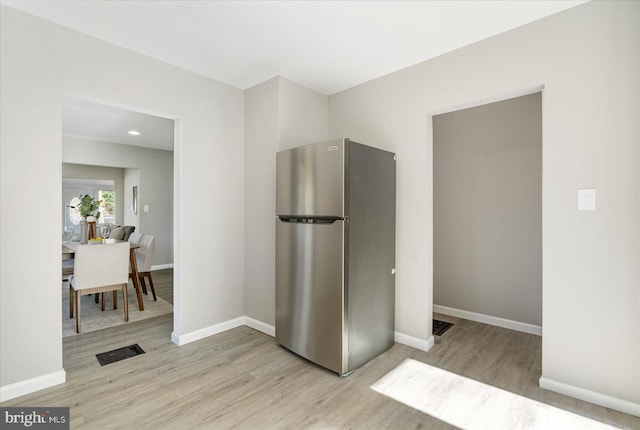 kitchen with light hardwood / wood-style floors and stainless steel refrigerator