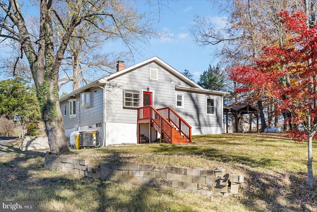 back of house featuring cooling unit and a yard