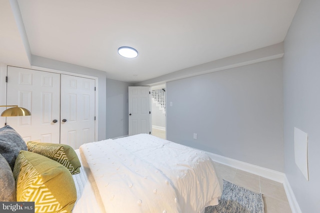 bedroom with tile patterned flooring and a closet