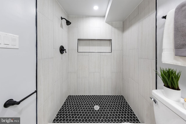 bathroom with toilet and tiled shower