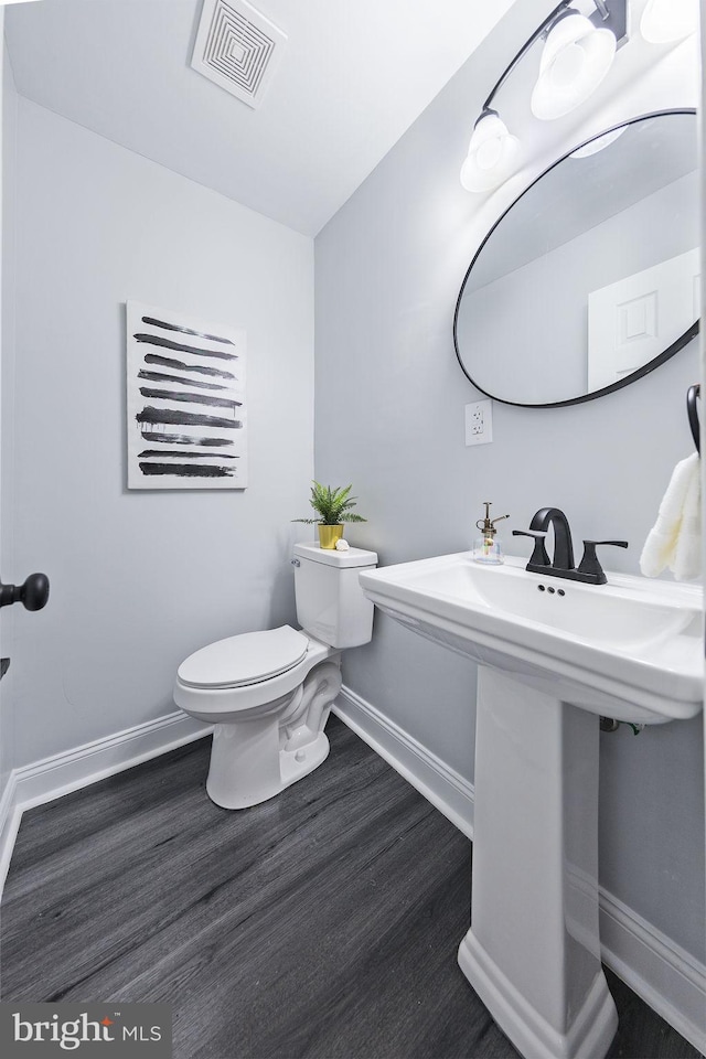 bathroom featuring hardwood / wood-style floors and toilet