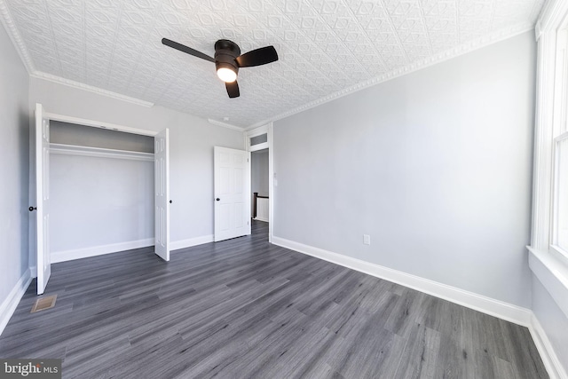 unfurnished bedroom with dark wood-type flooring, ornamental molding, a closet, and ceiling fan