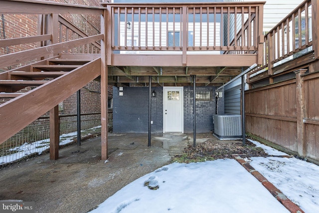 snow covered property entrance featuring central air condition unit