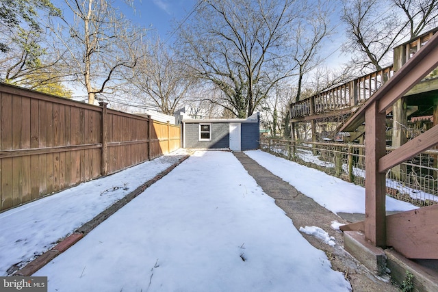 yard layered in snow featuring a storage unit