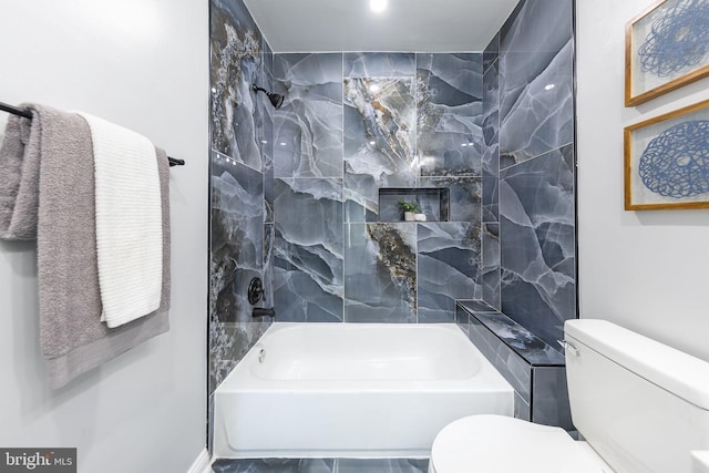 bathroom featuring tiled shower / bath and toilet