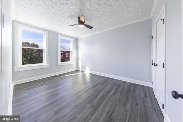 unfurnished bedroom with dark hardwood / wood-style flooring, ornamental molding, and ceiling fan