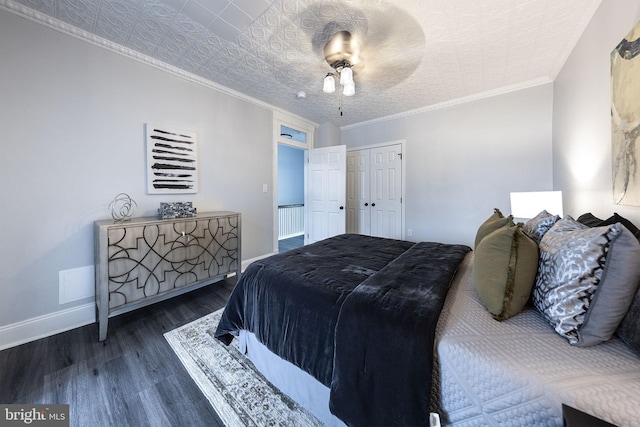 bedroom with dark wood-type flooring, ceiling fan, ornamental molding, and a closet