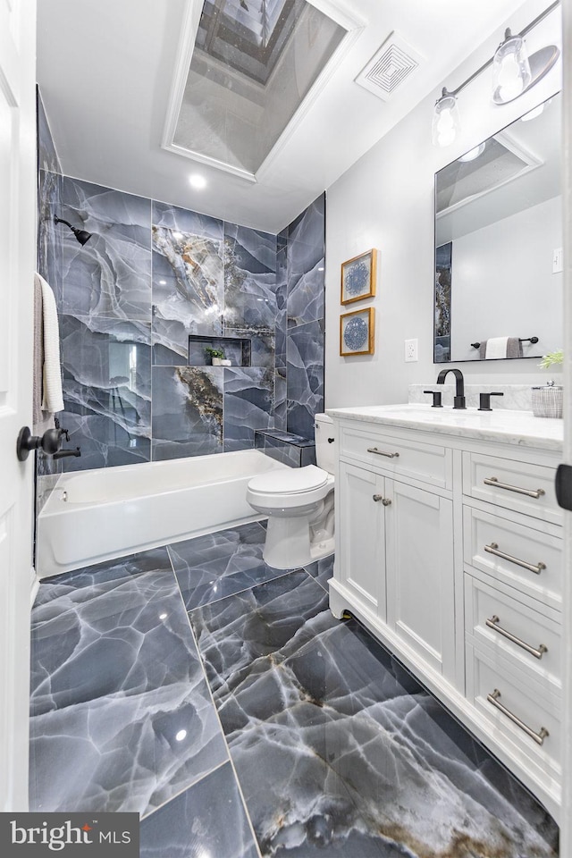 full bathroom with tiled shower / bath, vanity, and toilet