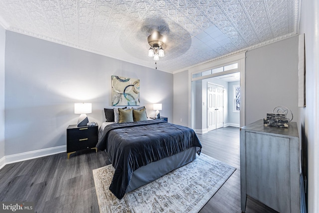 bedroom featuring dark wood-type flooring, ceiling fan, and crown molding