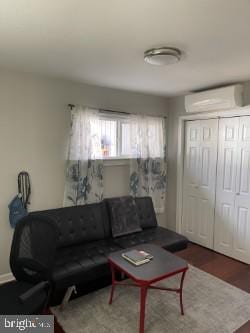 living room featuring dark hardwood / wood-style flooring and a wall mounted AC